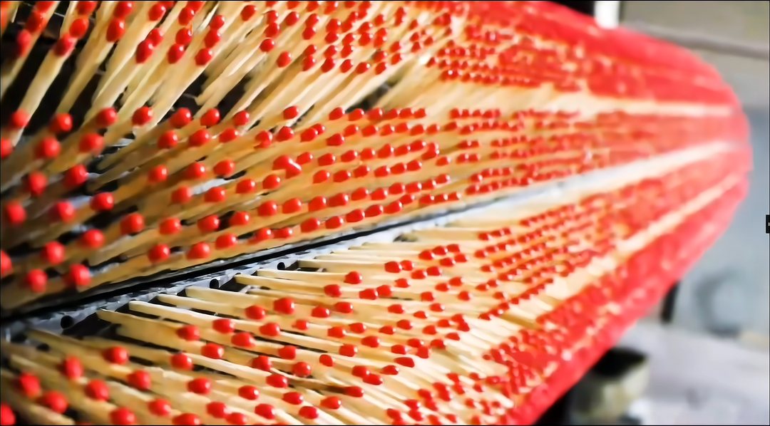 Rows of freshly dipped match sticks with red heads drying on the production rack